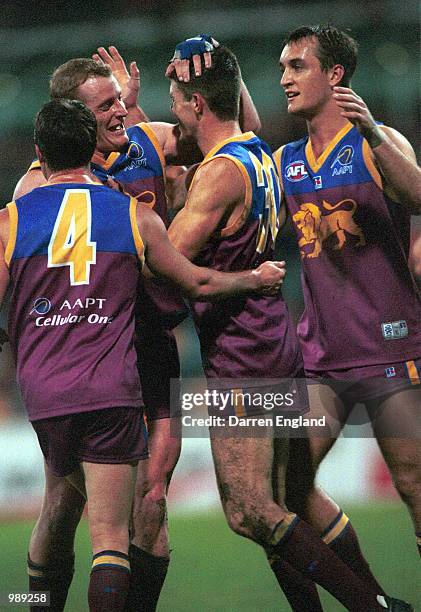 Craig McRae, Michael Voss and Daniel Bradshaw of Brisbane rush to congratulate team mate Robert Copeland after he kicked a goal against Hawthorn...