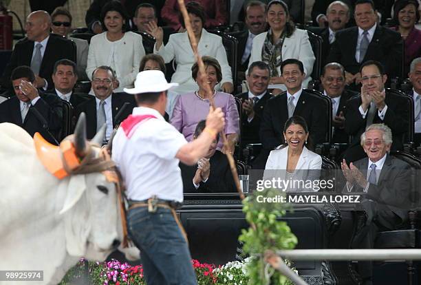 Costa Rican President-elect Laura Chinchilla , accompanied by her husband Jose Maria Rico , looks at a typical cart pulled by bulls, as it parades...