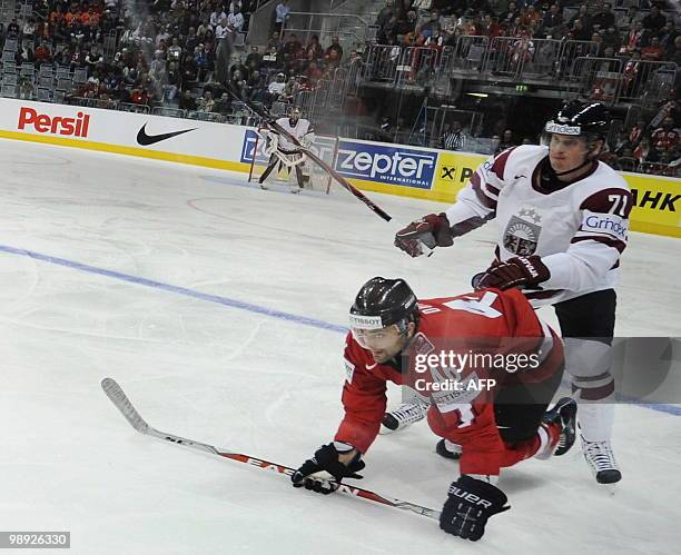 Switzerland's Paolo Duca and Latvia's Georgijs Pujacs vie during the IIHF Ice Hockey World Championship match Switzerland vs Latvia in the southern...