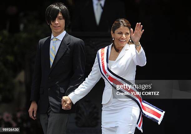 Costa Rican new President Laura Chinchilla waves to the crowd as she walks hand in hand with her son Jose Maria, after being sworn in at La Sabana...