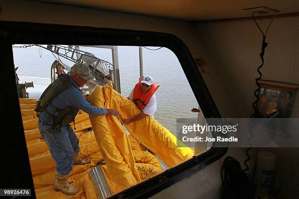 Fishermen use their shrimp boat to place oil booms into the water in an effort to protect the coast line from the massive oil spill on May 8, 2010...