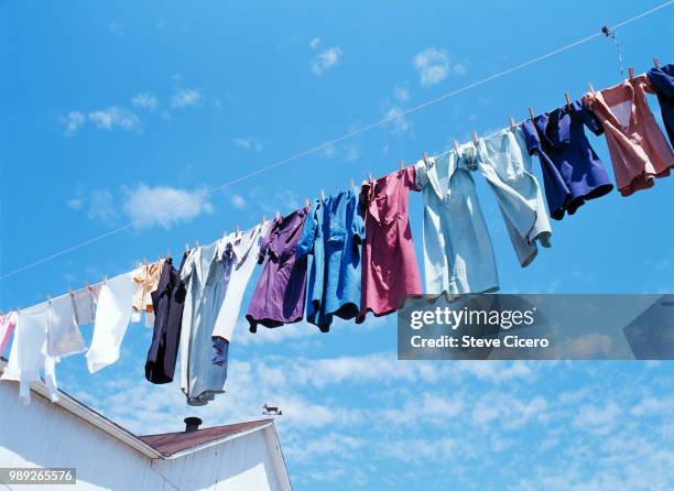 amish dresses blowing on clothesline - hanging clothes stock-fotos und bilder