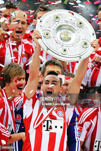 Diego Contento of Muenchen lifts the trophy after the Bundesliga match between Hertha BSC Berlin and FC Bayern Muenchen at Olympic Stadium on May 8,...
