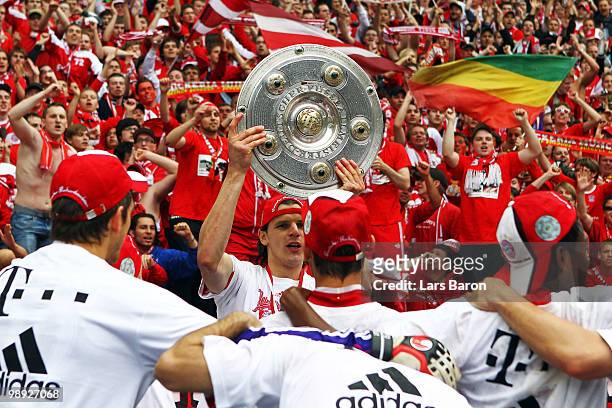 Daniel van Buyten of Muenchen lifts the trophy after the Bundesliga match between Hertha BSC Berlin and FC Bayern Muenchen at Olympic Stadium on May...