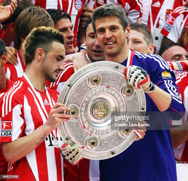 Goalkeeper Hans Joerg Butt of Muenchen holds the trophy together with team mate Diego Contento during the Bundesliga match between Hertha BSC Berlin...