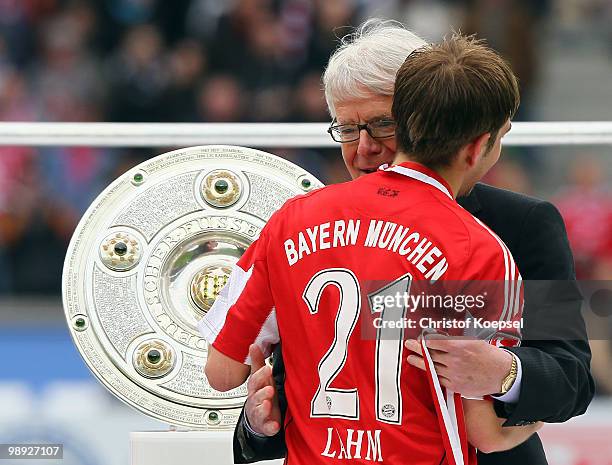 Rauball, president of Deutsche Fussball Liga embraces Philipp Lahm of Bayern on the podium after winning the German Champions trophy after winning...