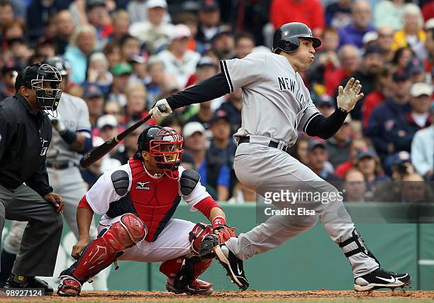 Mark Teixeira of the New York Yankees hits an RBI single in the third inning as Victor Martinez of the Boston Red Sox defends on May 8, 2010 at...