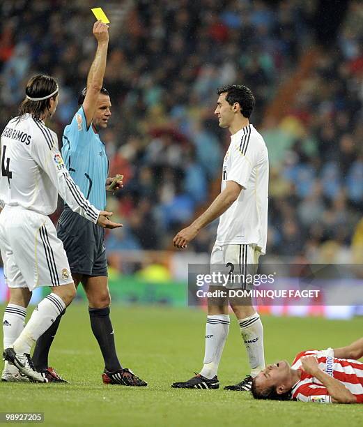 The referee shows a yellow card to Real Madrid's defender Alvaro Arbeloa during the Spanish league football match Real Madrid against Athletic Bilbao...