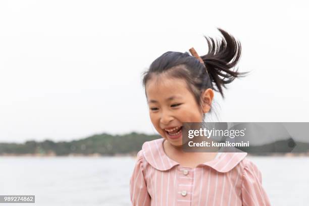 girl playing on a beach - kumikomini stock pictures, royalty-free photos & images