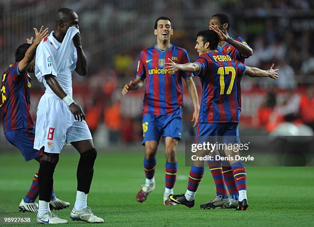 Pedro Rodriguez of Barcelona celebrates with Seydou Keita and Sergio Busquets while Didier Zokora of Sevilla looks on after Pedro scored Barcelona's...