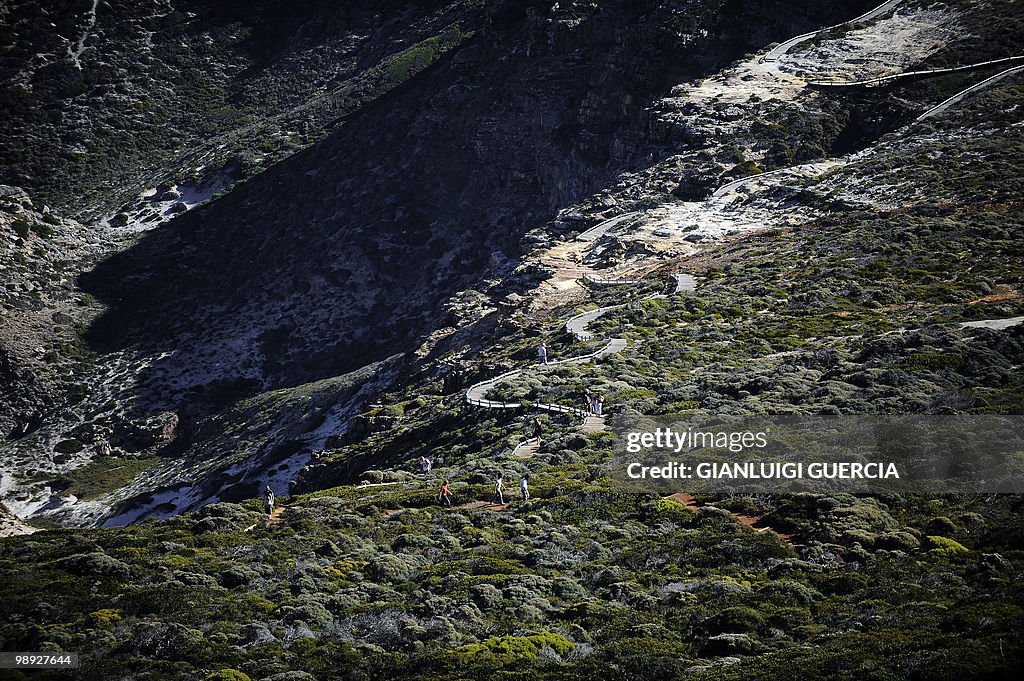 Tourists walk down a trail towards the C