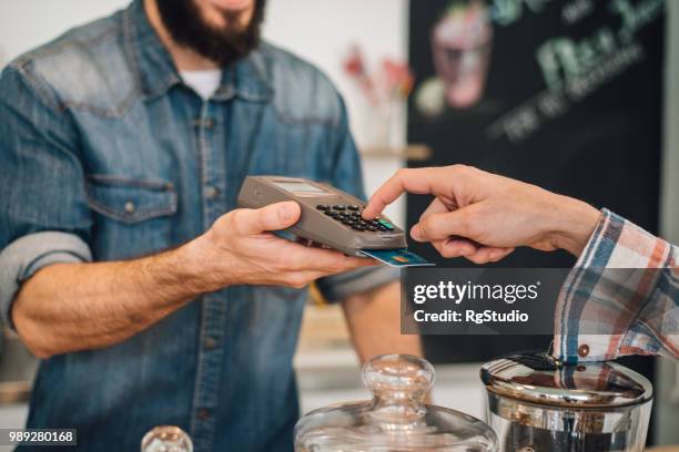 hombre de entrada entrada de pin en el lector de tarjetas de crédito - marcar el número de identificación personal fotografías e imágenes de stock