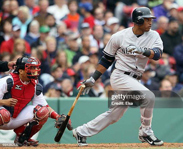 Robinson Cano of the New York Yankees hits a single in the fifth inning as Victor Martinez of the Boston Red Sox defends on May 8, 2010 at Fenway...