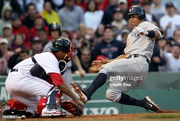 Alex Rodriguez of the New York Yankees slides home safely as Victor Martinez of the Boston Red Sox is unable to make the tag on May 8, 2010 at Fenway...