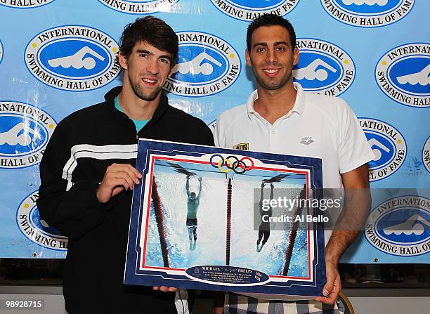 Michael Phelps and Milorad Cavic hold up their famous 100m Butterfly photo finish taken by Sports Illustrated photographer Heinz Kluetmeir which will...