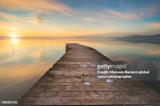 il pontile sul lago trasimeno al tramonto - lac trasimeno photos et images de collection