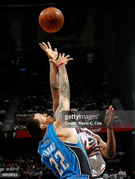 Matt Barnes of the Orlando Magic defends a shot by Joe Johnson of the Atlanta Hawks during Game Three of the Eastern Conference Semifinals during the...