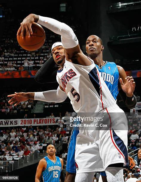 Josh Smith of the Atlanta Hawks grabs a rebound against Dwight Howard of the Orlando Magic during Game Three of the Eastern Conference Semifinals...