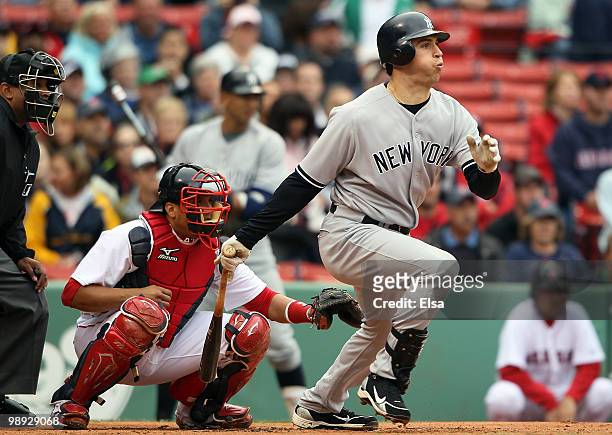 Mark Teixeira of the New York Yankees hits an RBI single in the first inning as Victor Martinez of the Boston Red Sox defends on May 8, 2010 at...