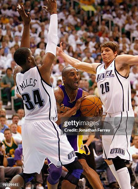 Kobe Bryant of the Los Angeles Lakers is defended by C.J. Miles and Kyle Korver of the Utah Jazz during Game Three of the Western Conference...