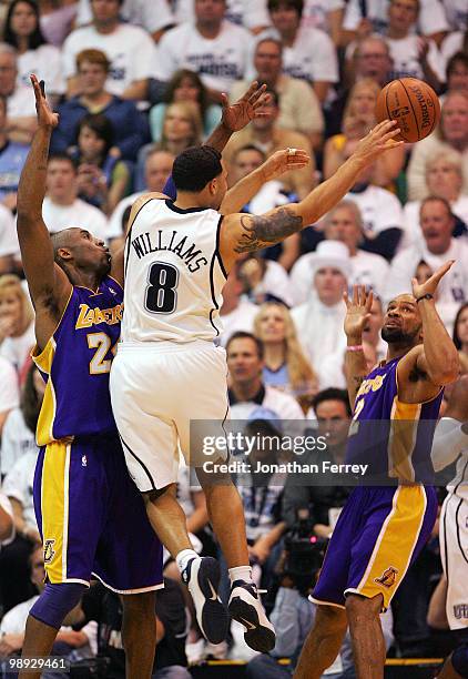 Deron Williams of the Utah Jazz passes the ball past Kobe Bryant and Derek Fisher of the Los Angeles Lakers during Game Three of the Western...