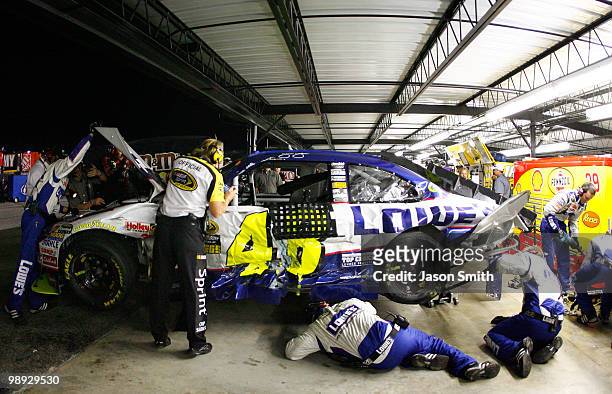 The crew of the Lowe's Chevrolet, driven by Jimmie Johnson, works on the car in the garage after Johnson crashed during the NASCAR Sprint Cup series...