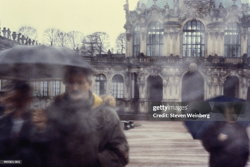 Germany, Dresden, Zwinger, people walking in rain