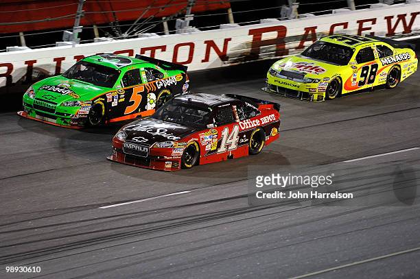 Tony Stewart, driver of the Old Spice / Office Depot Chevrolet races against Mark Martin, driver of the GoDaddy.com Chevrolet and Paul Menard, driver...