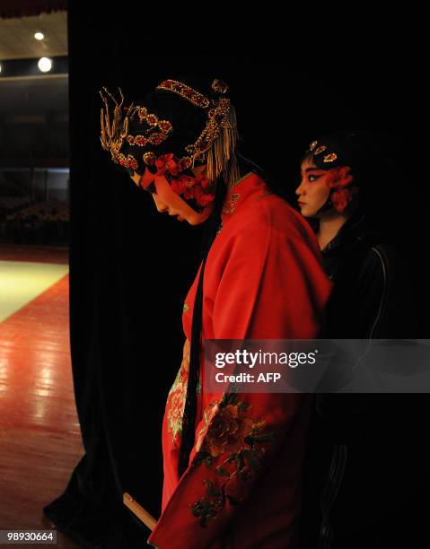 Young Chinese opera performers from the Anhui art college wait to rehearse for a Peking Opera performance at their school in Hefei, central China's...