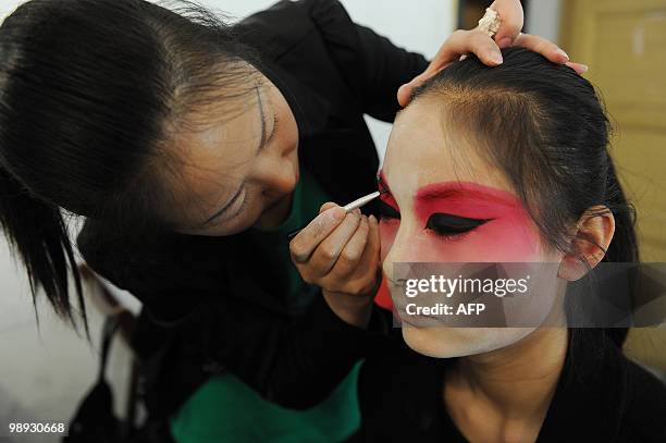 Young Chinese opera performer from the Anhui art college has her makeup done as she prepares for a Peking Opera performance at their school in Hefei,...