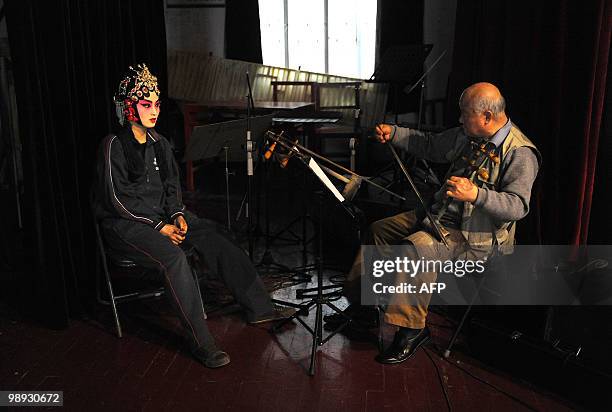 Young Chinese opera performer from the Anhui art college practices her songs at a rehearsal for a Peking Opera performance at their school in Hefei,...