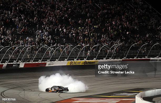 Denny Hamlin, driver of the FedEx Express Toyota, performs a burnout in celebration of winning the NASCAR Sprint Cup series SHOWTIME Southern 500 at...