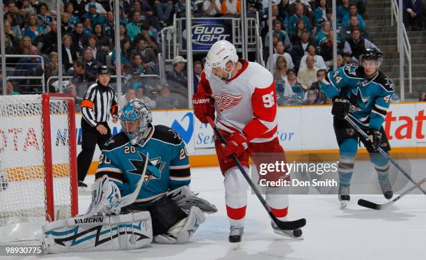 Tomas Holmstrom of the Detroit Red Wings tips the puck wide of Evgeni Nabokov of the San Jose Sharks as Marc-Edouard Vlasic looks on in Game Five of...