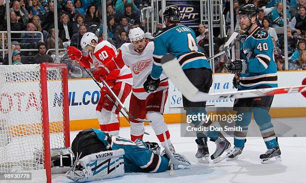 Henrik Zetterberg and Tomas Holmstrom of the Detroit Red Wings battle for control with Rob Blake, Kent Huskins and Evgeni Nabokov of the San Jose...
