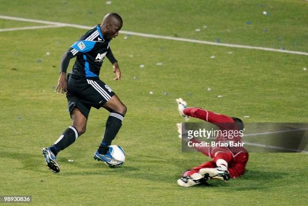 Cornell Glen of the San Jose Earthquakes dribbles the ball around the reach of goalkeeper Bouna Coundoul of the New York Red Bulls before kicking the...