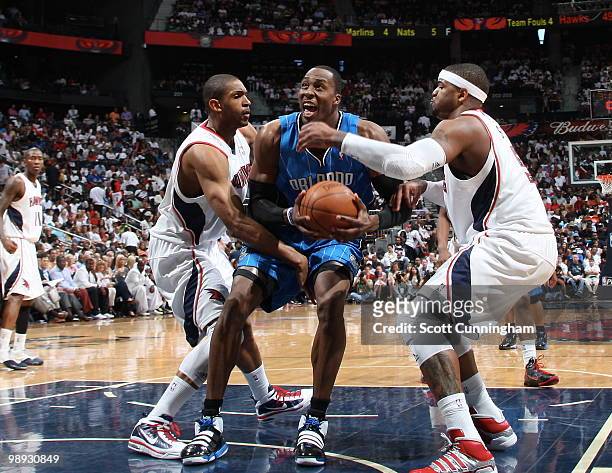 Dwight Howard of the Orlando Magic is defended by Josh Smith and Al Horford of the Atlanta Hawks in Game Three of the Eastern Conference Semifinals...