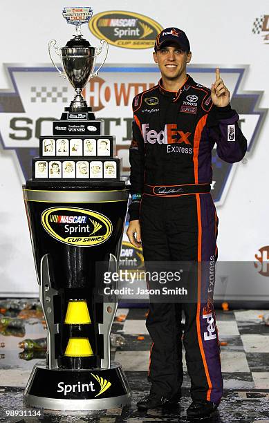 Denny Hamlin, driver of the FedEx Express Toyota, celebrates with the trophy in victory lane in celebration of winning the NASCAR Sprint Cup series...