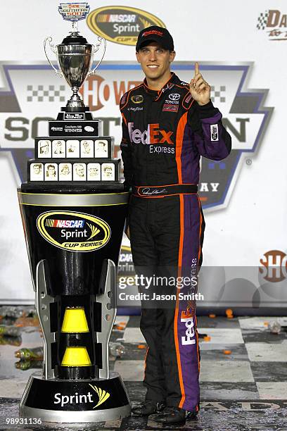 Denny Hamlin, driver of the FedEx Express Toyota, celebrates with the trophy in victory lane in celebration of winning the NASCAR Sprint Cup series...