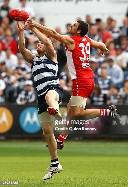 Heath Grundy of the Swans attempts to spoil a mark by Cameron Mooney of the Cats during the round seven AFL match between the Geelong Cats and the...