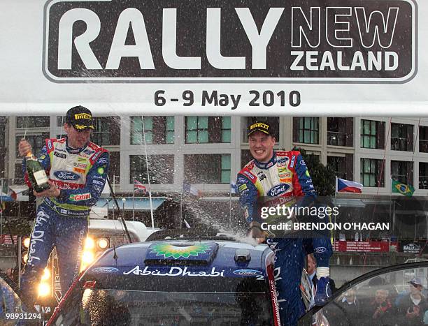 Finnish driver Jari-Matti Latvala and co-driver compatriot Miikka Anttila spray champagne as they celebrate winning the Rally of New Zealand, round...