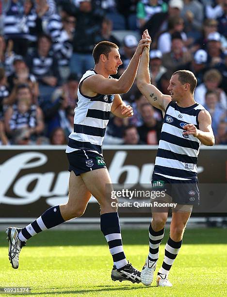 Mark Blake is congratulated by James Kelly of the Cats after scoring a goal during the round seven AFL match between the Geelong Cats and the Sydney...