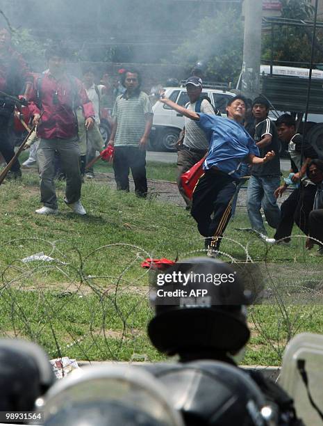 Unified Communist Party of Nepal supporters throw objects at riot police in Kathmandu on May 9, 2010. A peaceful sit-in protest turned violent after...