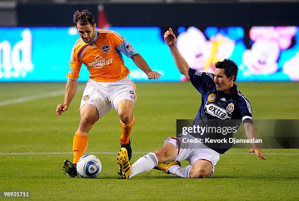 Brian Mullan of Houston Dynamo is tackled by Sacha Kljestan of Chivas USA during the second half of the MLS soccer game on May 8, 2010 at the Home...