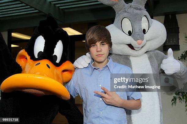 Justin Bieber poses with Daffy Duck and Bugs Bunny during his visit to Six Flags Magic Mountain on May 8, 2010 in Valencia, California.