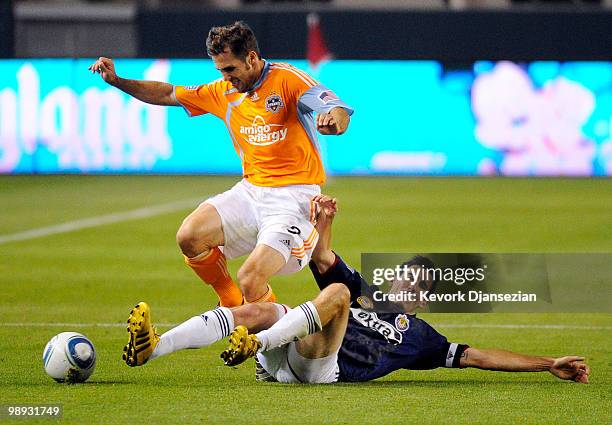 Brian Mullan of Houston Dynamo is tackled by Sacha Kljestan of Chivas USA during the second half of the MLS soccer game on May 8, 2010 at the Home...