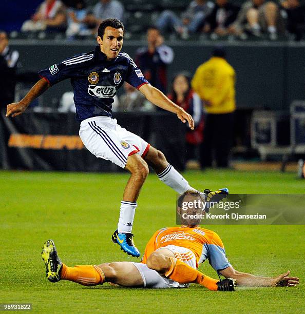 Jonathan Bornstein Chivas USA follows through on shot on goal as Brian Mullan of Houston Dynamo looks during the first action of the MLS soccer match...