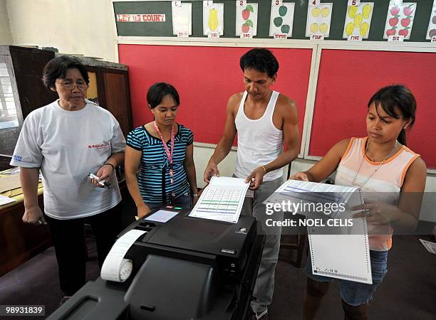 Mock voter cast his ballot to a Precint Count Optical Scanner during the final testing and sealing of automated election counting machines a day...