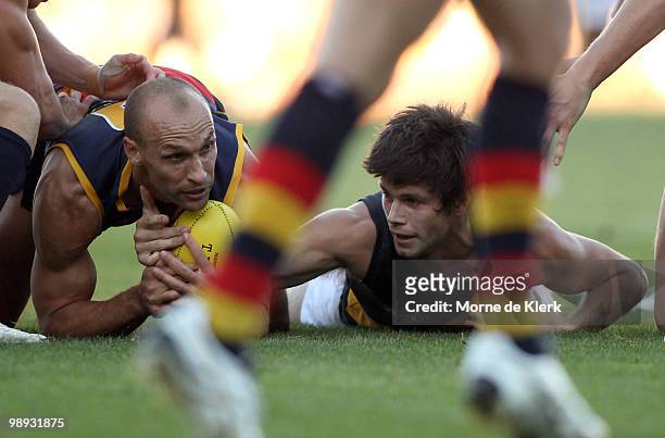 Tyson Edwards of the Crows and Trent Cotchin of the Tigers fight for the ball on the ground during the round seven AFL match between the Adelaide...