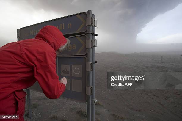 Tourist makes a smiley face in an ash covered sign as the ash cloud from Eyjafjoell volcano spreads in the background, on May 8, 2010 in...