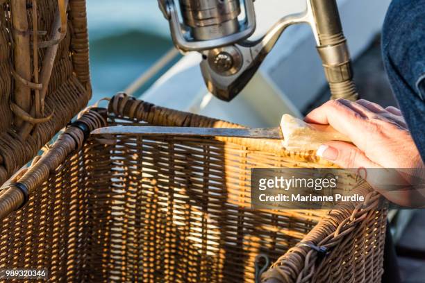 a lady's hand taking a fish filleting knife out of a tackle box - fishing tackle box stockfoto's en -beelden